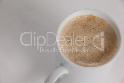 Close-up of white mug of coffee with creamy froth