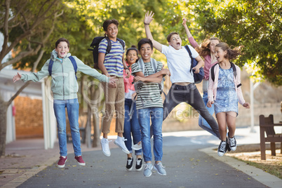 Smiling school kids having fun on road in campus