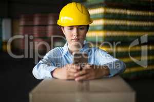 Female factory worker using mobile phone