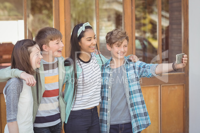 Group of school friends taking selfie with mobile phone