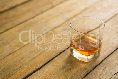 Glass of whisky on wooden table