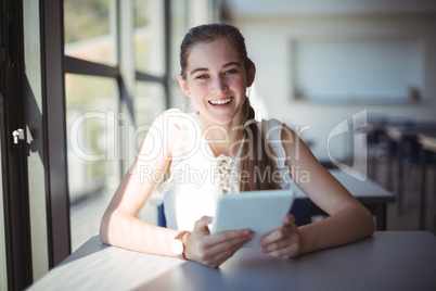 Schoolgirl using digital tablet in classroom