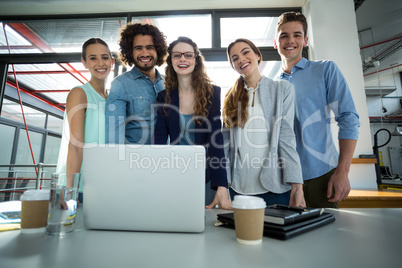 Portrait of smiling business team standing together in meeting