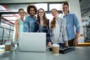 Portrait of smiling business team standing together in meeting