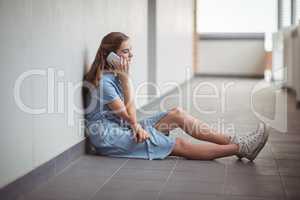 Schoolgirl talking on mobile phone in corridor