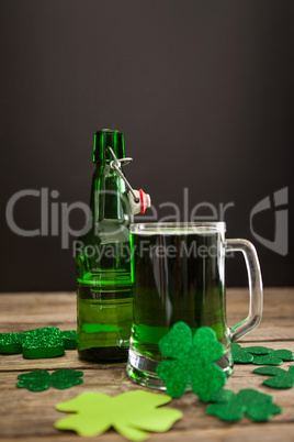 Mug of green beer, beer bottle and shamrocks for St Patricks Day