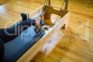 Woman practicing stretching exercise on reformer