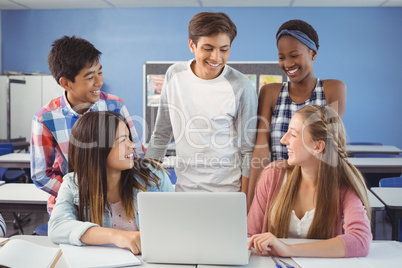 Group of students using laptop in classroom