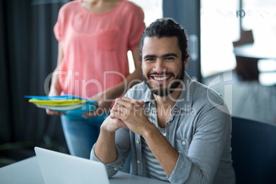 Smiling business executive sitting in office