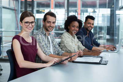 Portrait of smiling business executives sitting together in meeting Portrait of smiling business executives sitting together in meeting