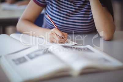 Mid section of schoolgirl studying in classroom Mid section of schoolgirl studying in classroom