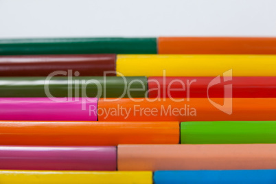 Colored pencils arranged in interlock pattern on white background