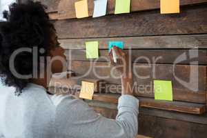 Female graphic designer looking at sticky notes