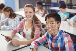 Students with digital tablet and laptop in classroom