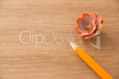 Close-up of orange color pencil with pencil shaving