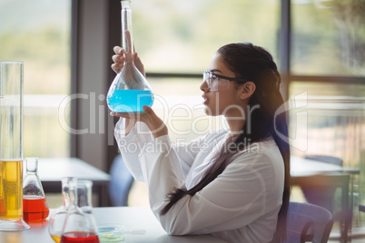 Attentive schoolgirl doing a chemical experiment in laboratory