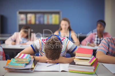 Tired schoolboy sleeping in classroom