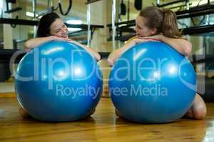 Happy women leaning on fitness ball