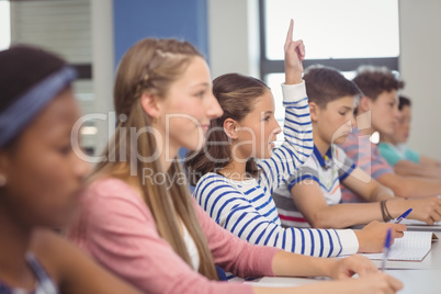 Student raising hand in classroom