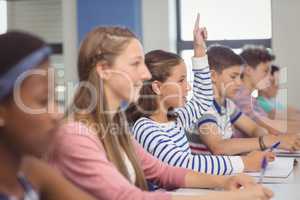 Student raising hand in classroom