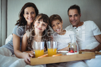 Parents and kids having breakfast in bed