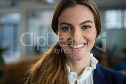 Smiling female executive standing in creative office