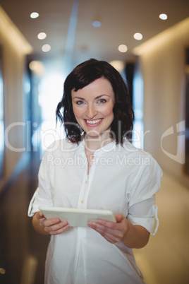 Portrait of female business executive holding digital tablet