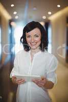 Portrait of female business executive holding digital tablet