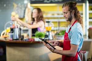 Shop assistant using a digital tablet in the shop