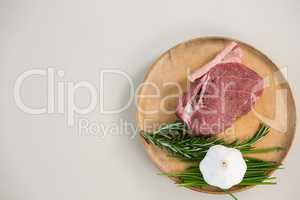 Sirloin chop, rosemary herb and garlic on wooden tray