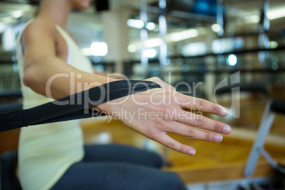 Woman practicing stretching exercise on reformer