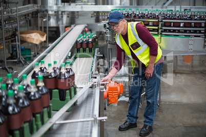 Male factory worker inspecting production line