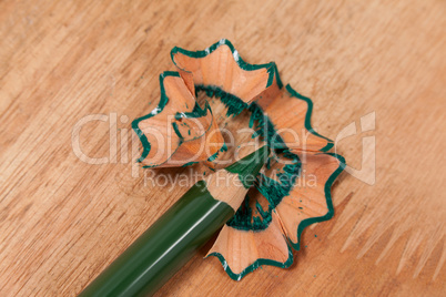 Close-up of green colored pencil with shavings