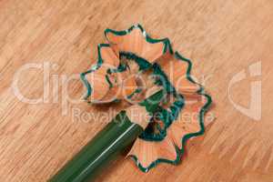 Close-up of green colored pencil with shavings