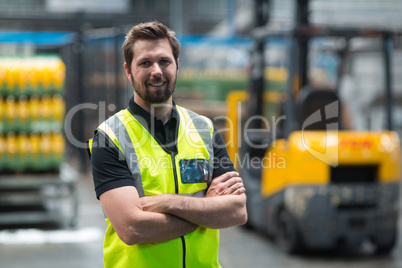 Factory worker standing with arms crossed in factory