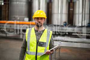 Portrait of factory worker holding clipboard