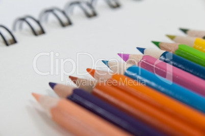 Close-up of colored pencils and notebook