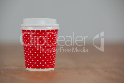 Disposable coffee cup on wooden background