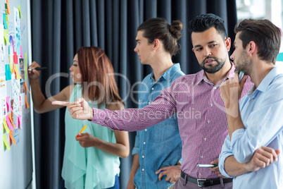 Business executives discussing over sticky notes