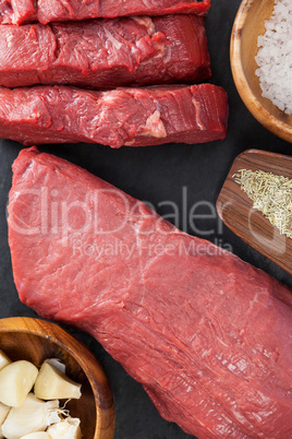 Beef steak, salt and spices on black slate plate