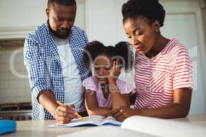 Parents assisting daughter with homework