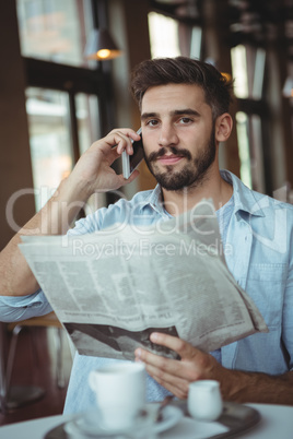 Executive talking on mobile phone in cafÃ?Â©