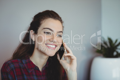 Female executive talking on mobile phone in office