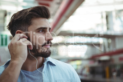 Thoughtful executive listening to music on headphones