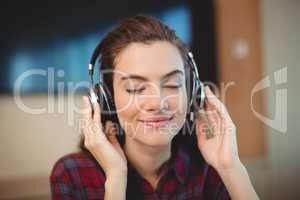 Female graphic designer listening music on headphones