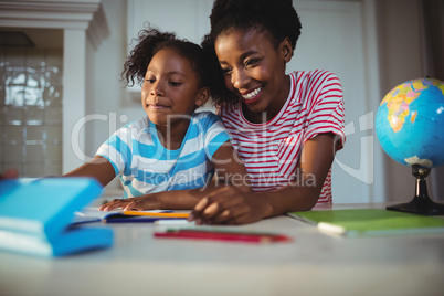 Mother assisting daughter with homework