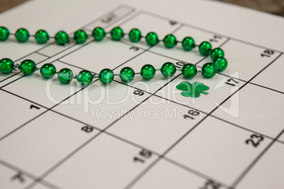 St. Patricks Day shamrock and beads kept on calendar