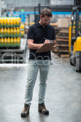Factory staff writing on clipboard