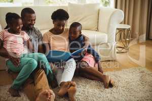 Parents and kids sitting together on sofa with photo album