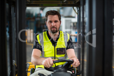 Portrait of factory worker driving forklift